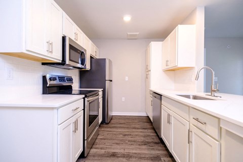 a kitchen with white cabinets and stainless steel appliances