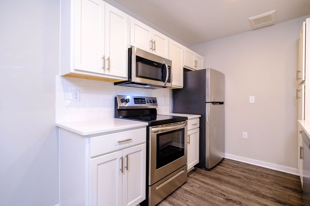 a kitchen with white cabinets and stainless steel appliances