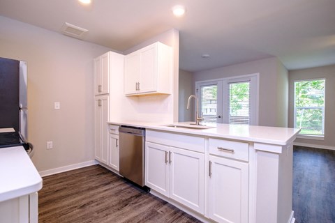a kitchen with white cabinets and a stainless steel dishwasher