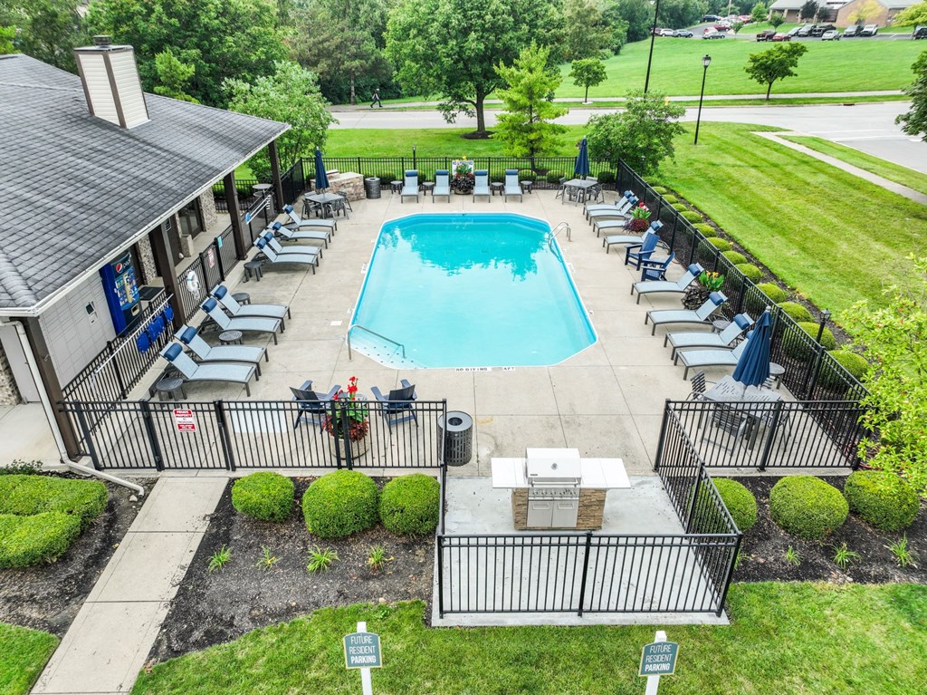 an aerial view of a resort style swimming pool with lounge chairs and umbrellas