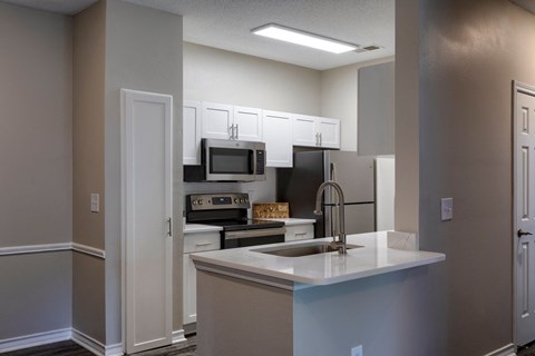 a kitchen with white cabinets and stainless steel appliances