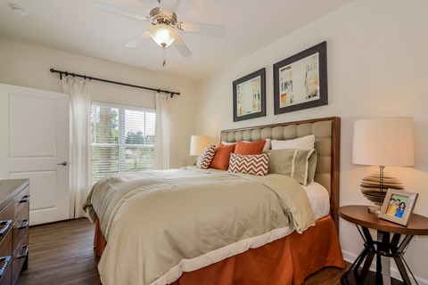 A bedroom with a large bed and a ceiling fan.