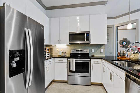 a kitchen with stainless steel appliances and white cabinets