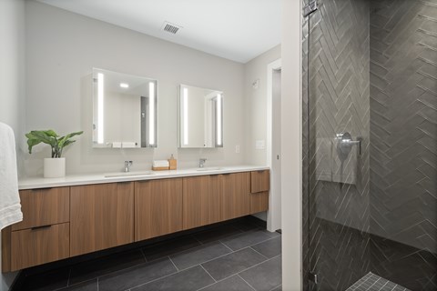 A bathroom with a wooden vanity and a large mirror.