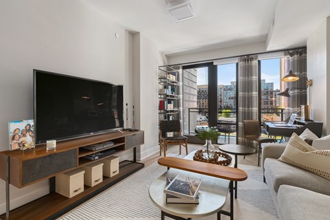 A living room with a television and a view of the city.