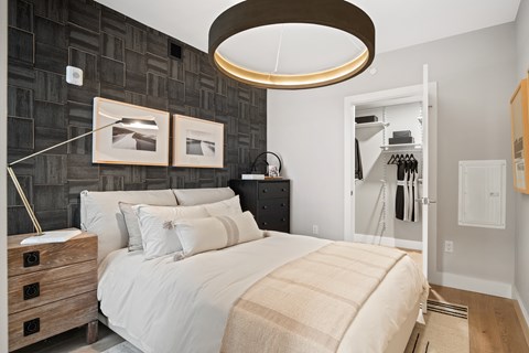A bedroom with a large bed and a wooden dresser.