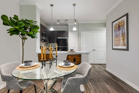 A modern dining room with a glass table and chairs.