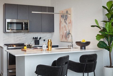 a kitchen with a sink and a counter with chairs