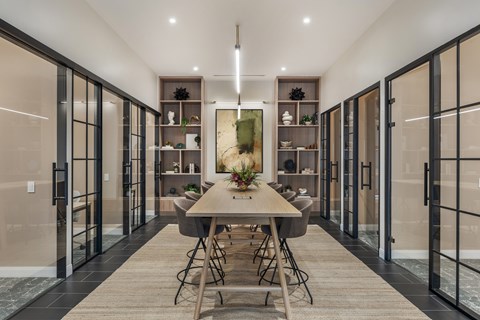 A modern dining room with a long table and chairs.