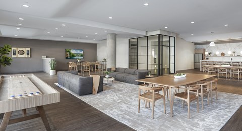 A modern living room with a shuffleboard table in the foreground.