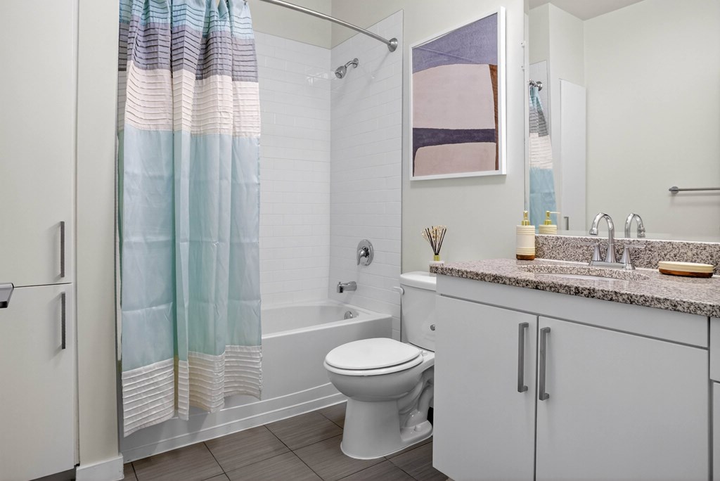 A bathroom with a toilet, sink, and shower.