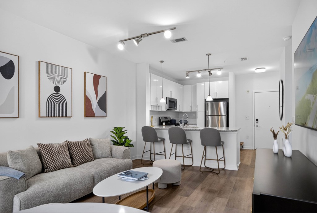 A modern living room with a grey sofa and a white coffee table.