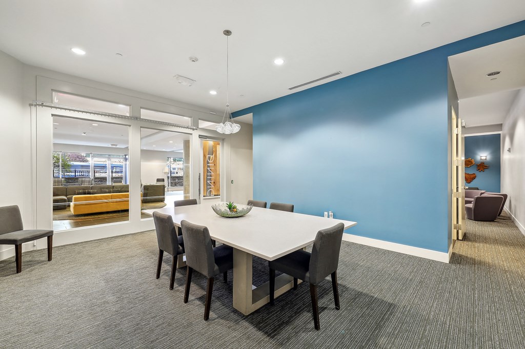 a conference room with a white table and chairs and a blue accent wall