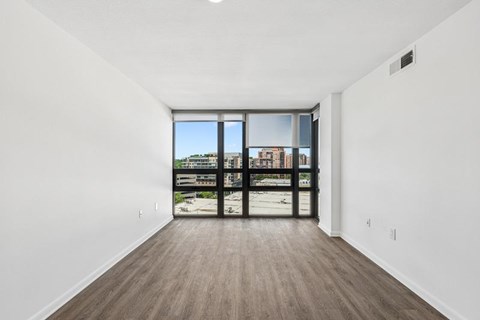 A room with a large window and a wooden floor.