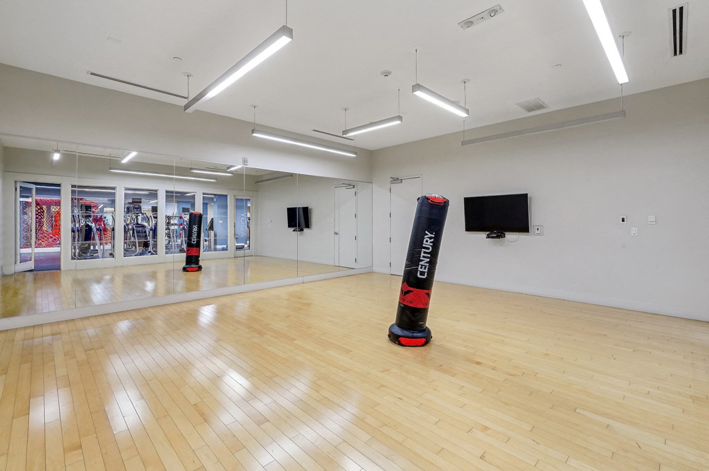 a large room with a wooden floor and two punching bags
