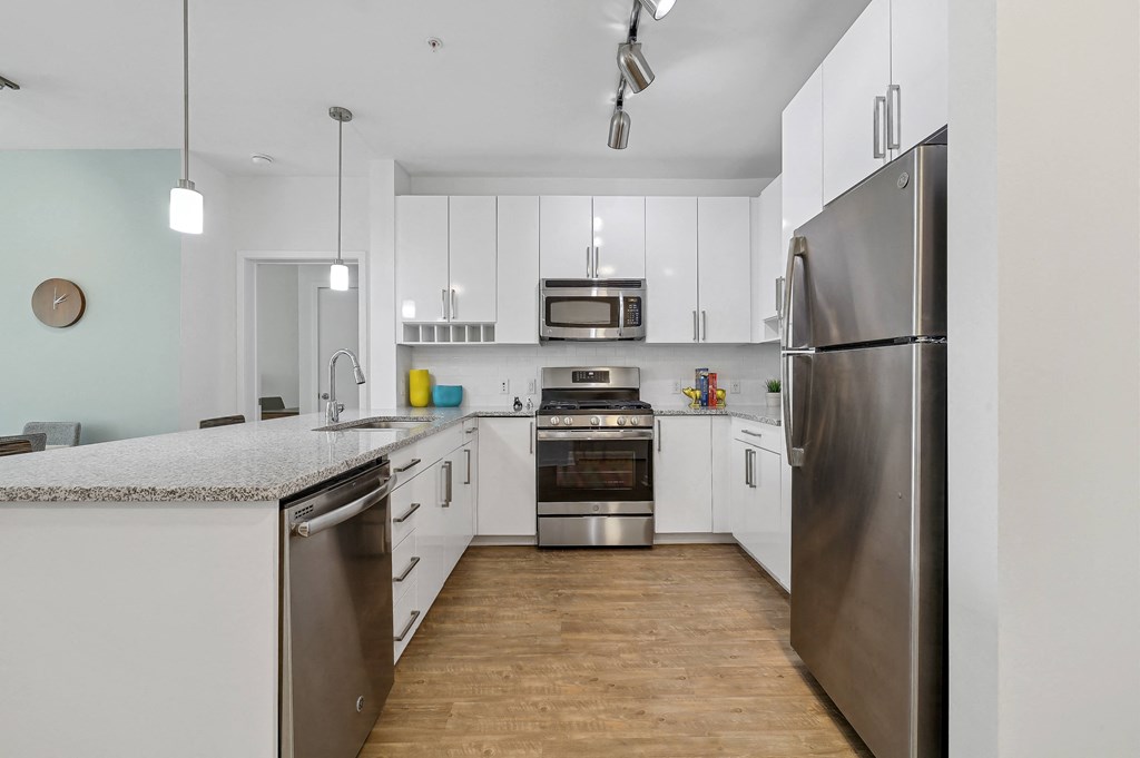 a large kitchen with white cabinets and stainless steel appliances