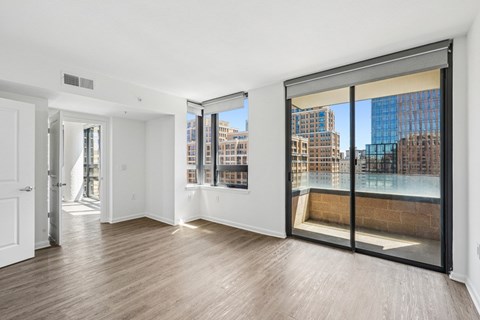 A room with a view of the city through large windows.