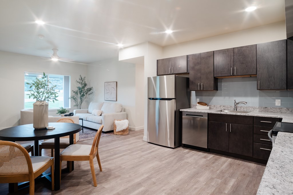 A kitchen with a refrigerator, sink, and cabinets.