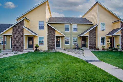 a row of houses with a sidewalk and grass
