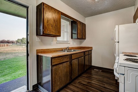 a kitchen with a sink and a refrigerator and a window