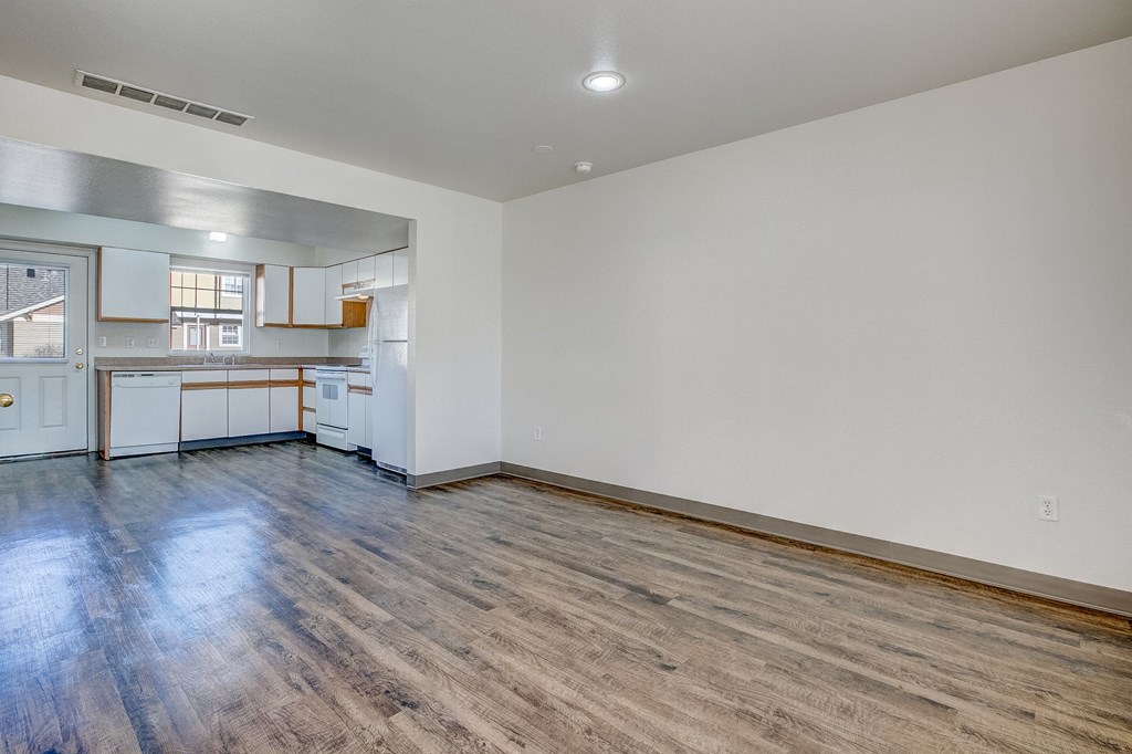 A room with a kitchen area and a dining table.