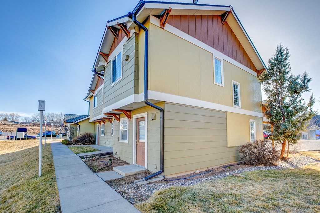 A two-story house with a red roof and beige siding.