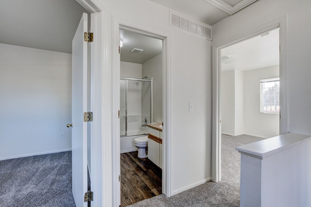 A white bathroom with a toilet, sink, and mirror.