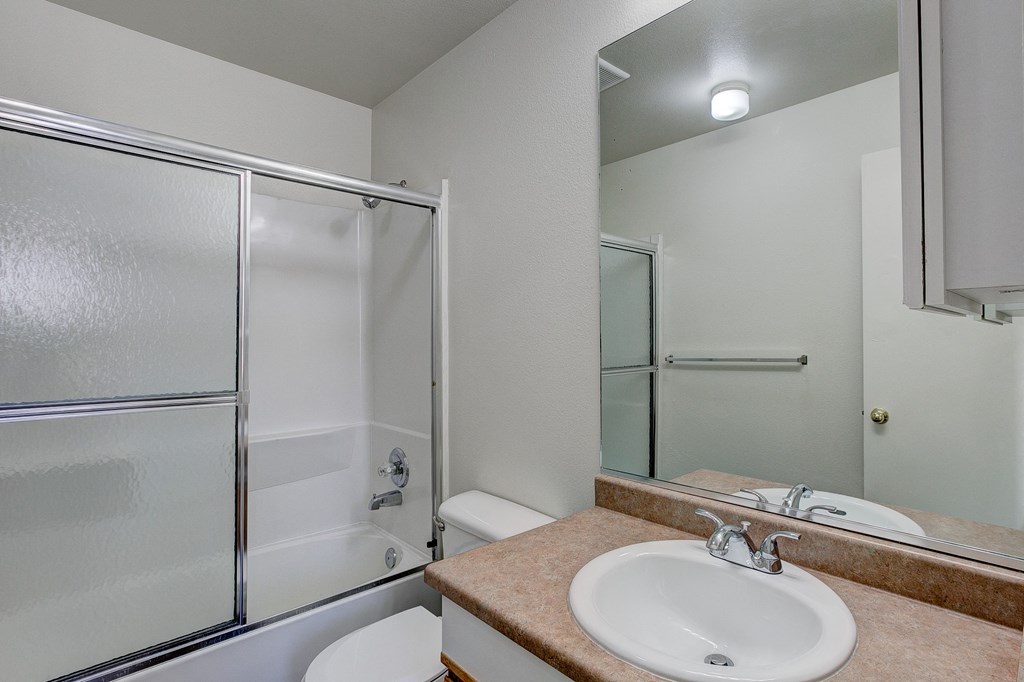 A bathroom with a sink, toilet, and shower.