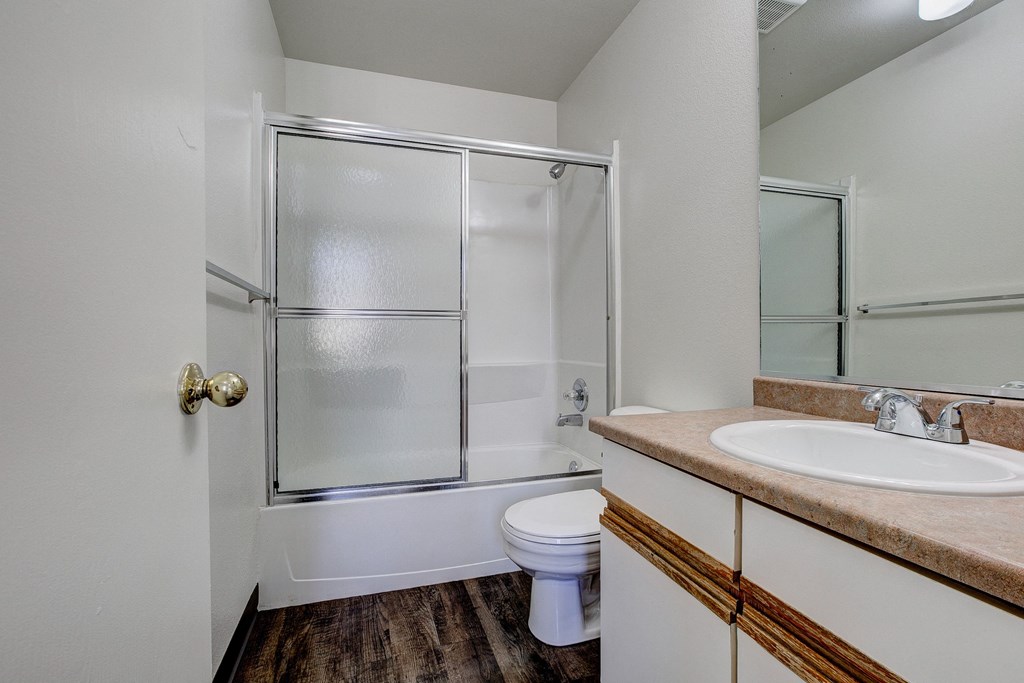 A bathroom with a toilet, sink, and shower.