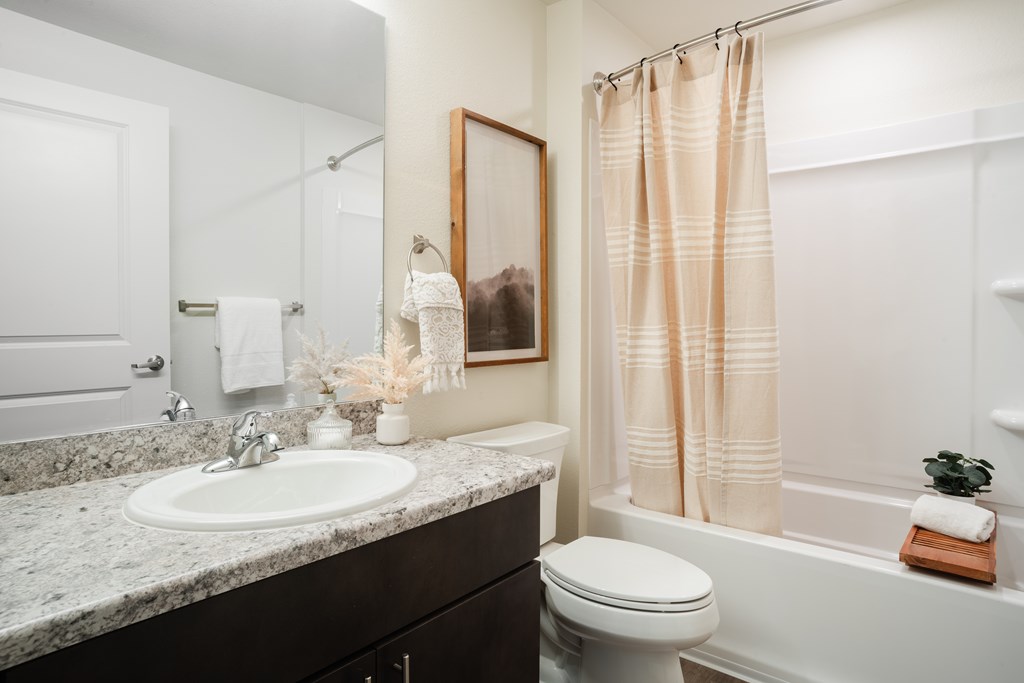 A bathroom with a toilet, sink, and shower.