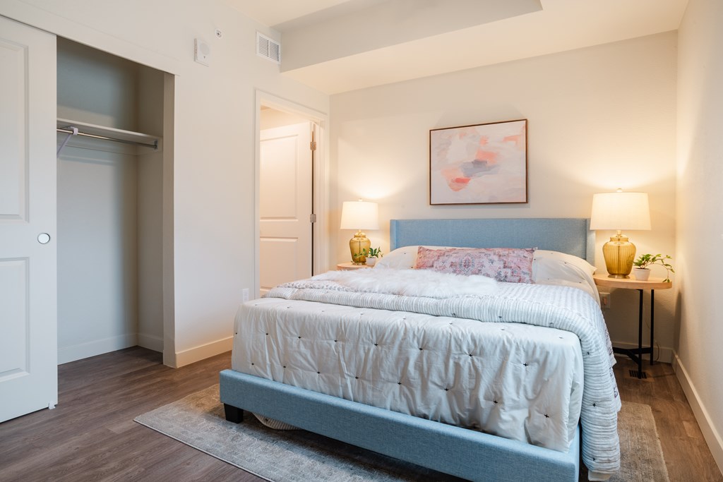 A bedroom with a large bed and a painting above it.