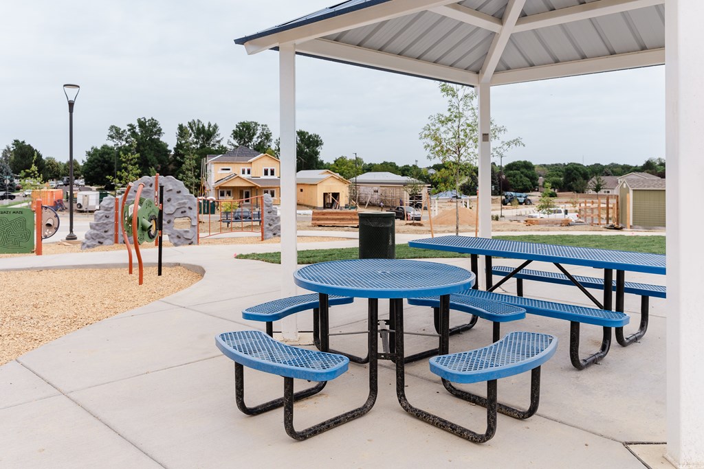 A playground with a picnic table and swings.