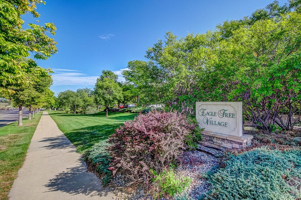 a park with a sidewalk and a sign that reads beach area alliance