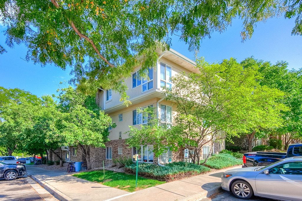 an apartment building with cars parked in front of it