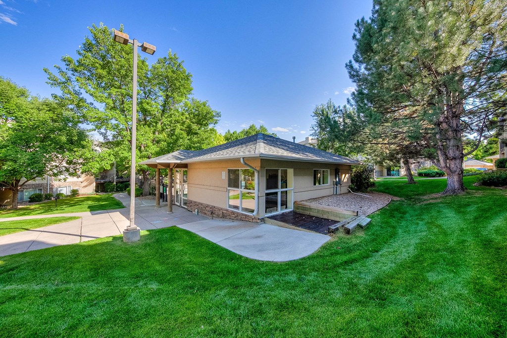 a bungalow with a porch and a yard with grass and trees