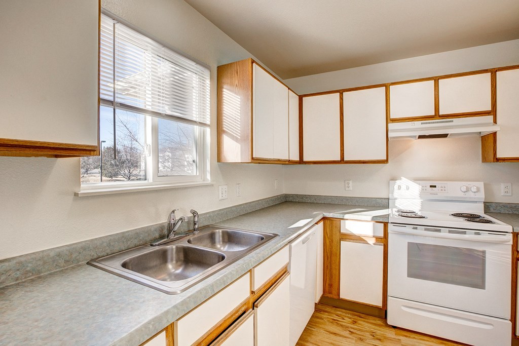 A kitchen with white cabinets and a stove top oven.