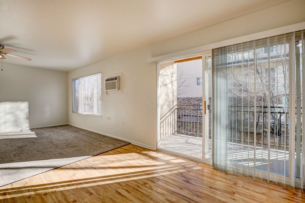 A room with a ceiling fan and a window with blinds.