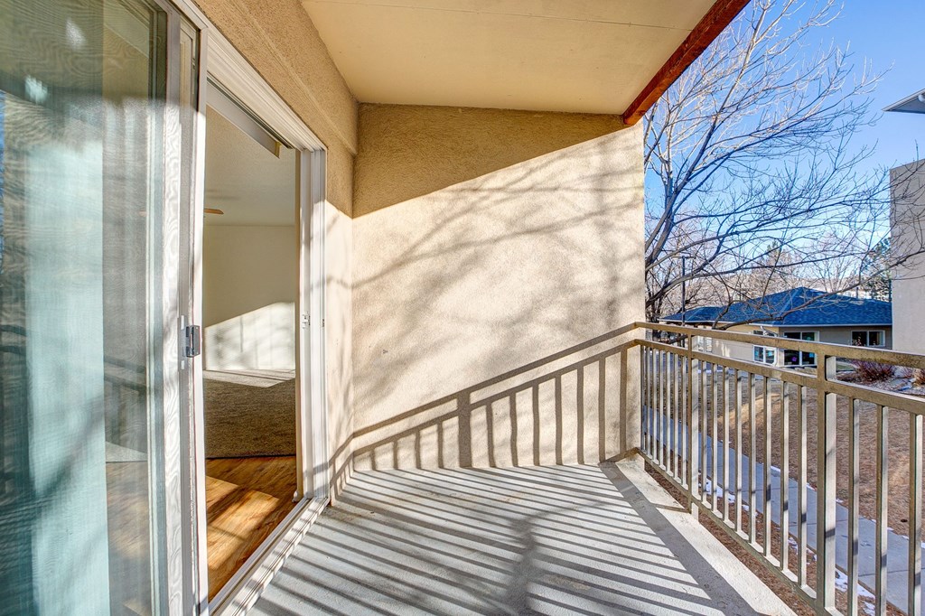 A balcony with a glass door and a railing.
