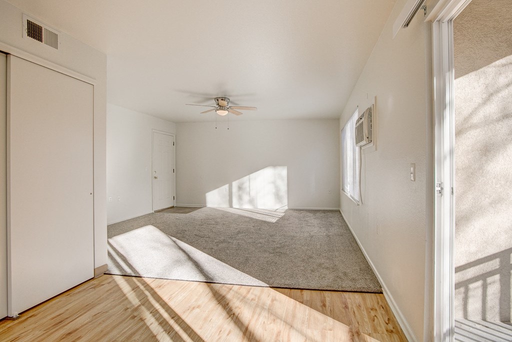A room with a ceiling fan and a carpeted floor.