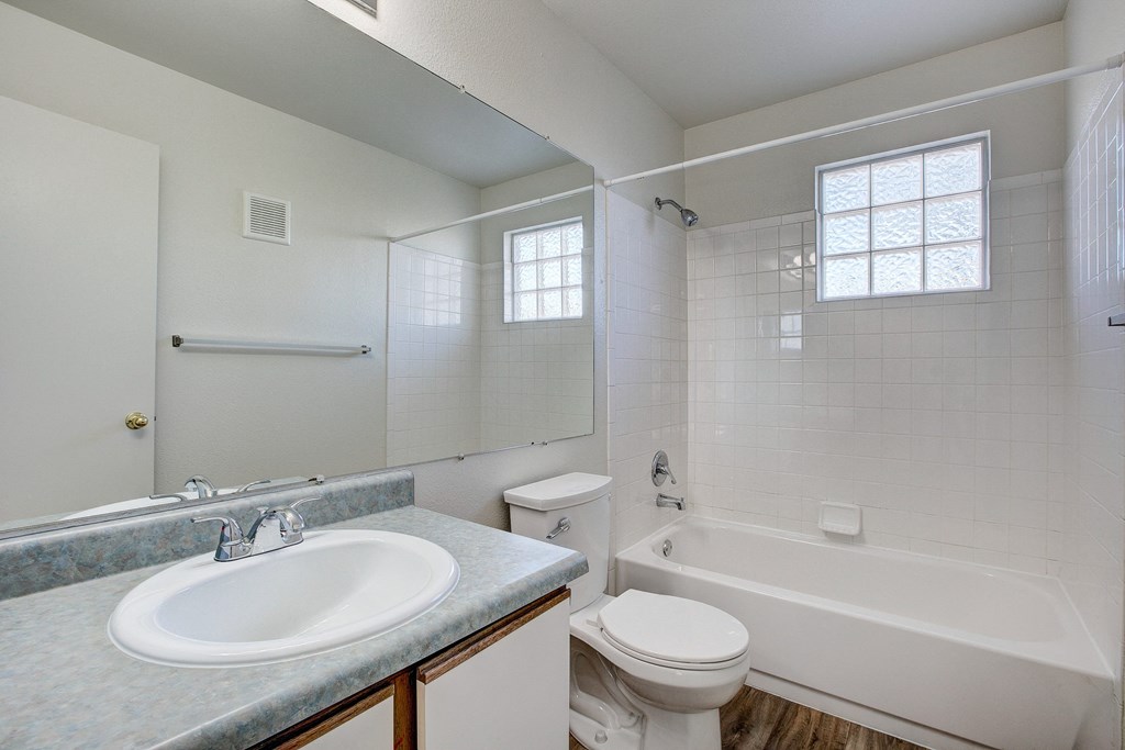 A white bathroom with a sink, toilet, and bathtub.
