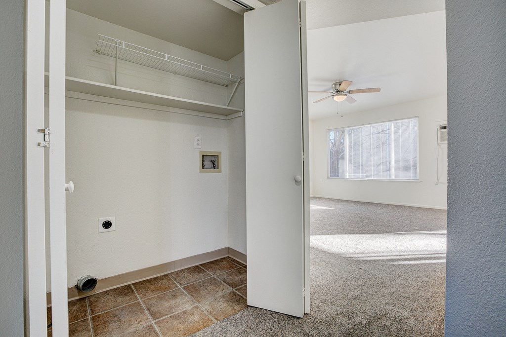 A room with a ceiling fan and a doorway leading to another room.