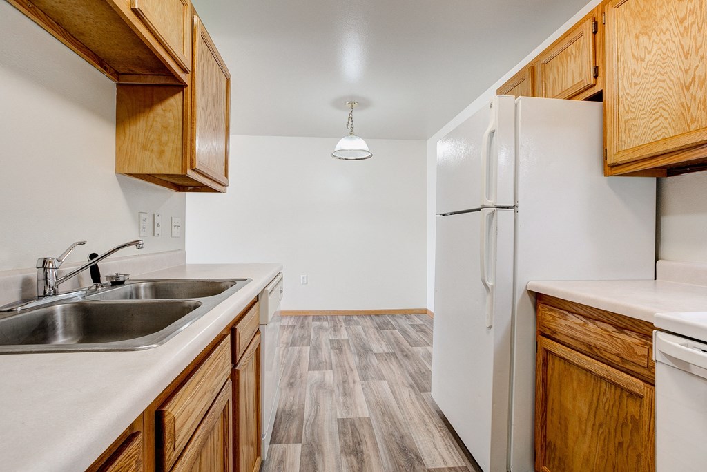a kitchen with wooden cabinets and a sink and a refrigerator
