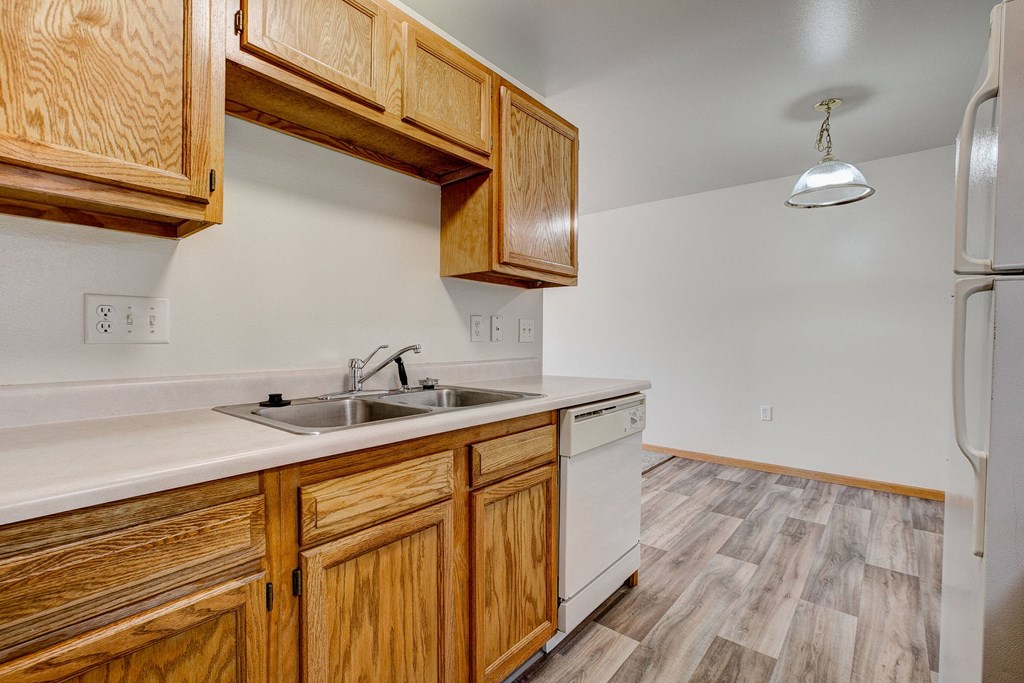 a kitchen with wooden cabinets and a sink and a refrigerator