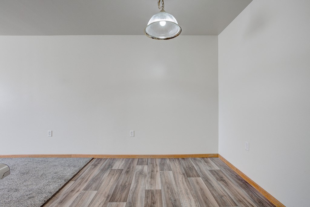 a living room with wood floors and a white wall