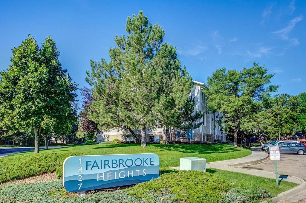 a view of fairbrooke heights apartments with trees and a sign