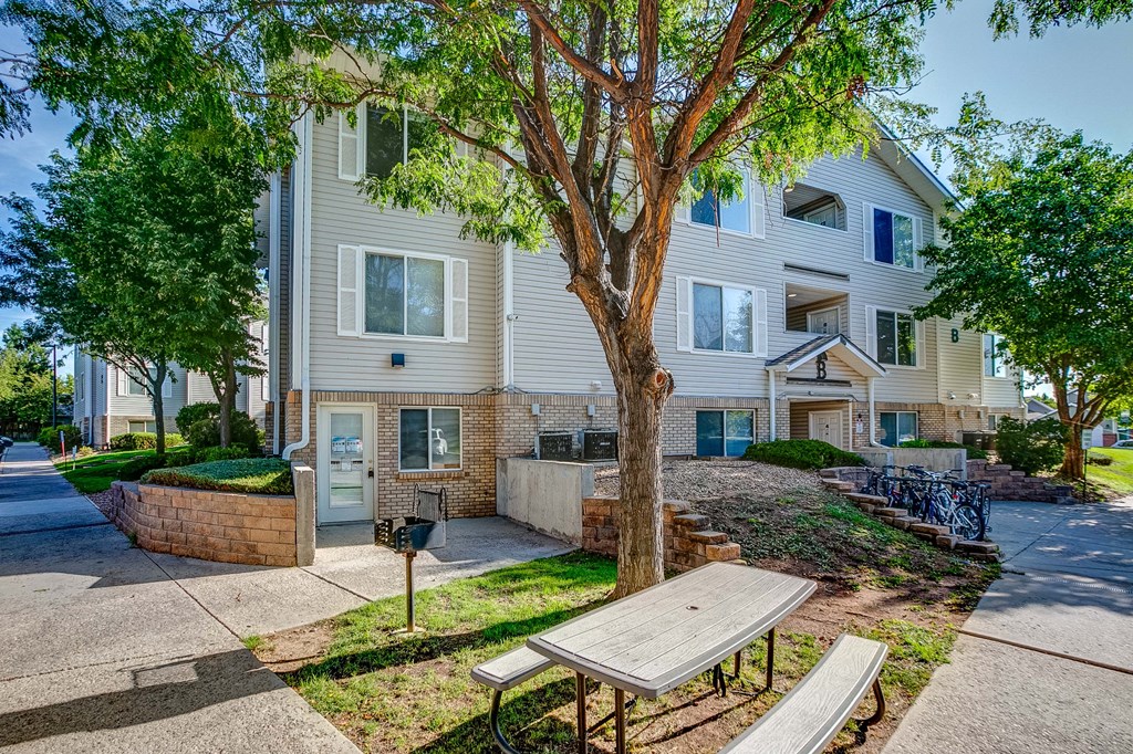 a picnic table in front of an apartment building