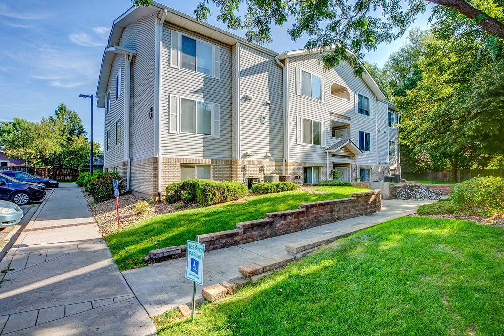 an apartment building with a sidewalk in front of it