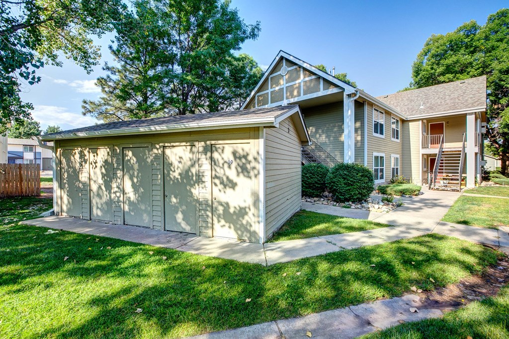 a small garage with a lawn in front of a house