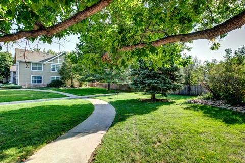 a walkway through a yard in front of a house