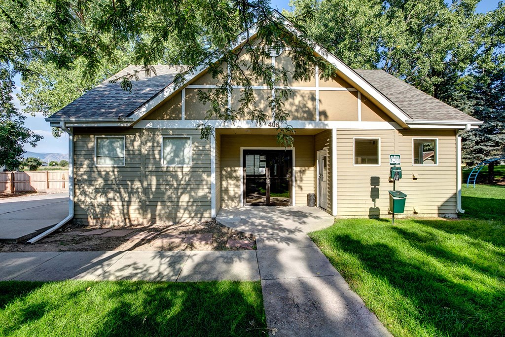 a small yellow house with a sidewalk in front of it